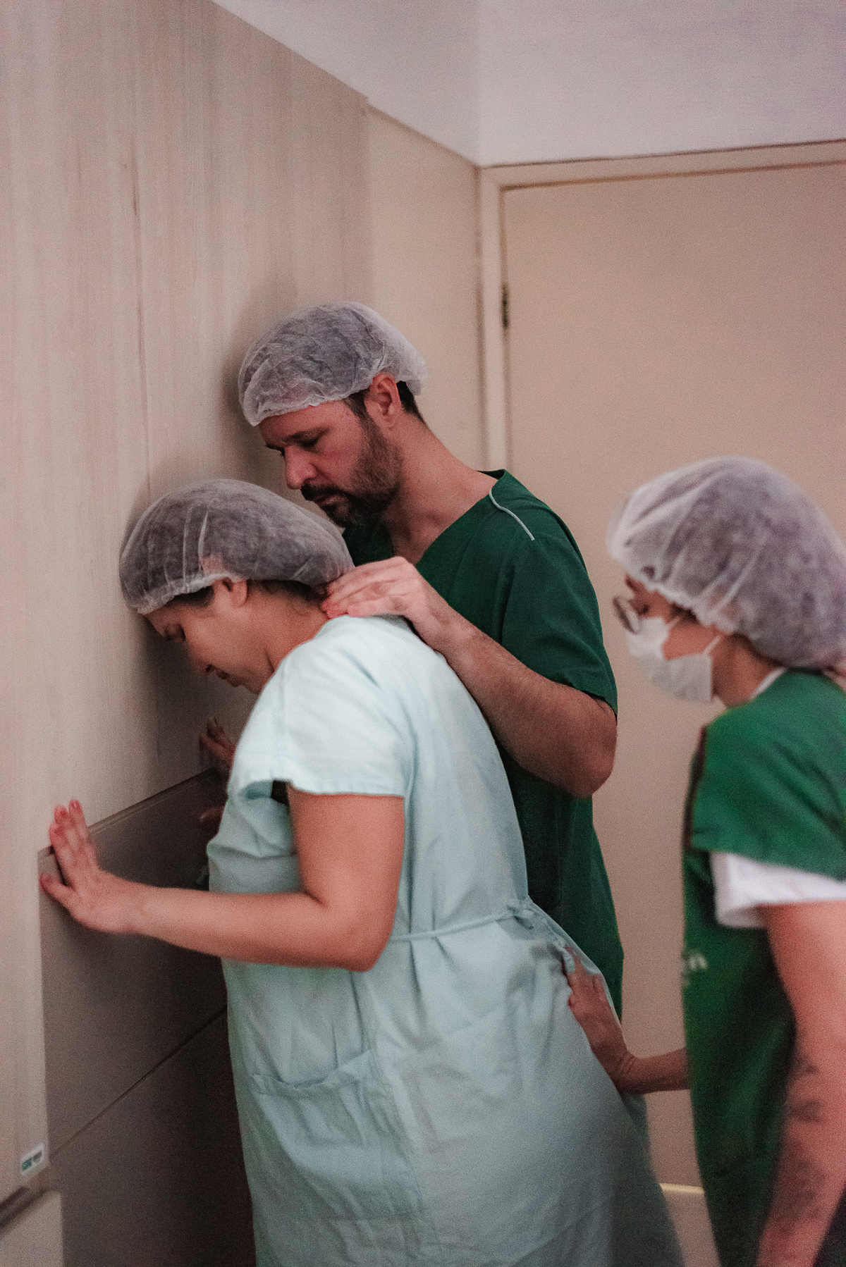 fotografia de parto pelo fotografo de parto andré pontes - doula e marido dando apoio à mulher em trabalho de parto