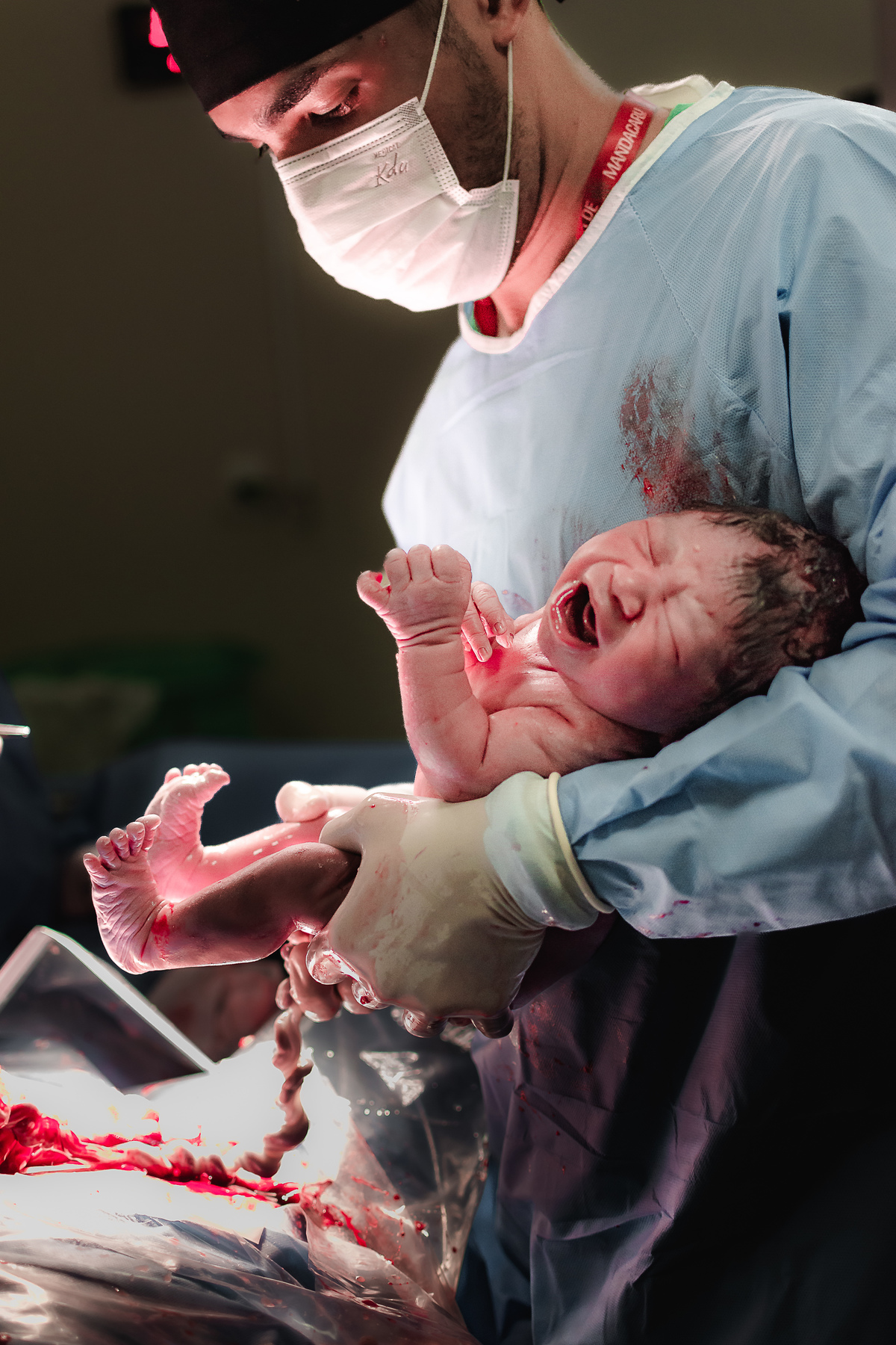 fotografia de parto pelo fotografo de parto andré pontes - bebê no colo do obstetra
