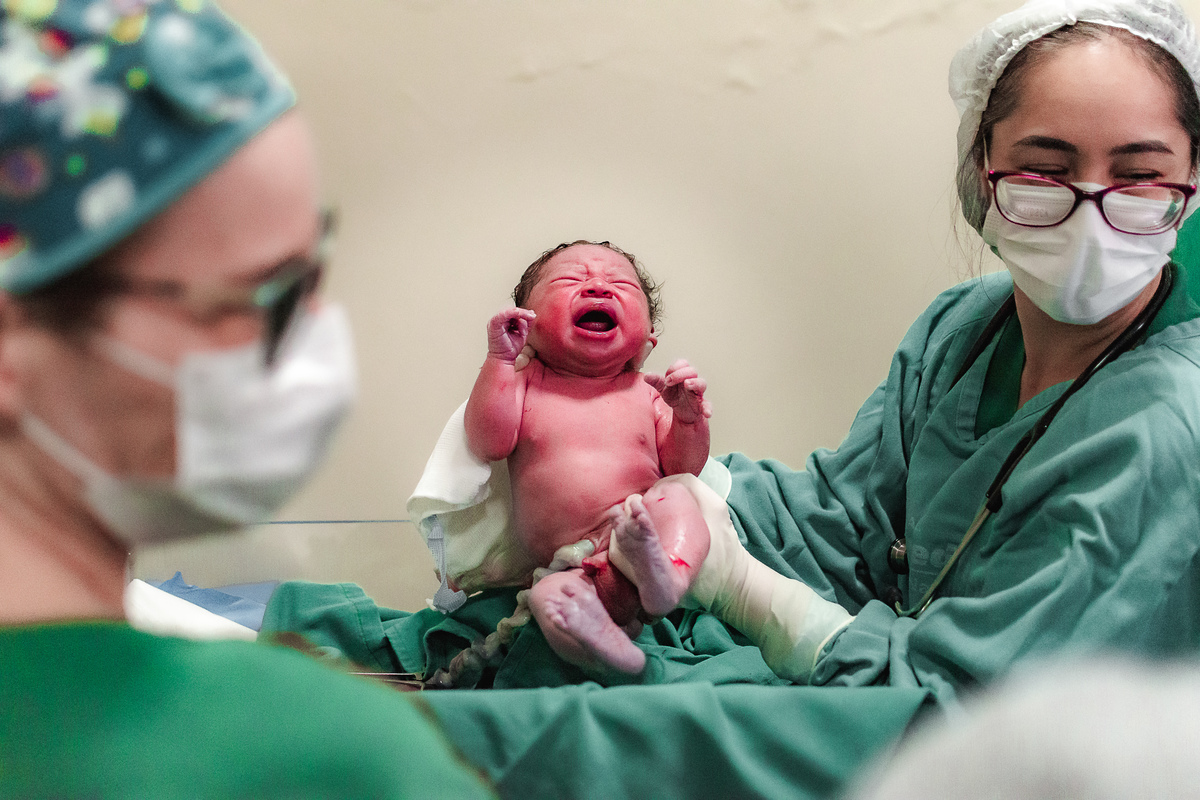 fotografia de parto pelo fotografo de parto andré pontes - pediatra mostrando o bebê à mãe