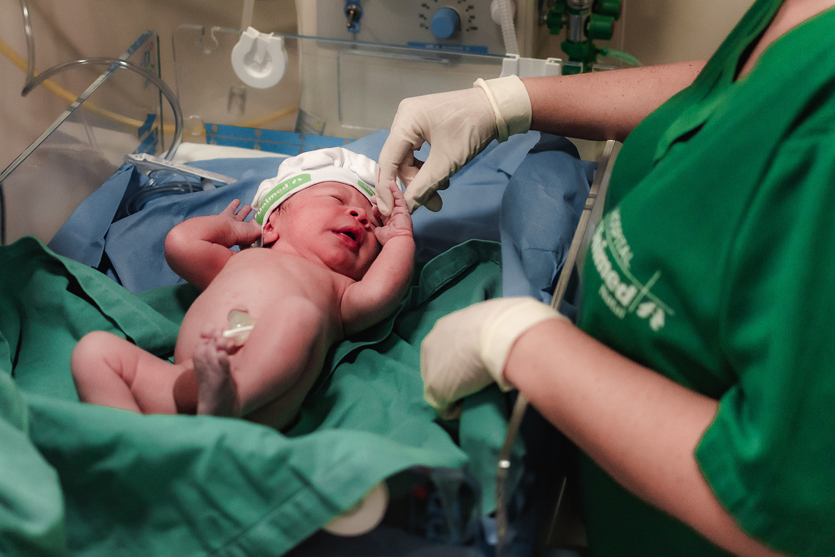 fotografia de parto pelo fotografo de parto andré pontes - bebê no berço aquecido