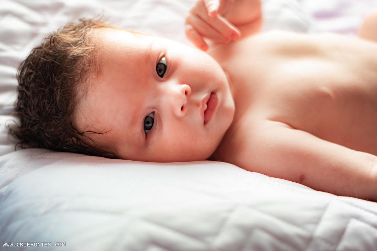 Bebê deitado sobre a cama