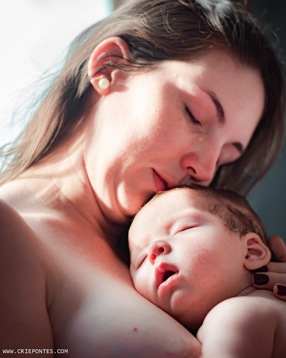 Mamãe emocionada com o bebê no colo