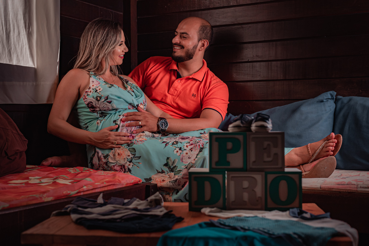 O casal se diverte brincando entre si e com o bebê ainda na barriga