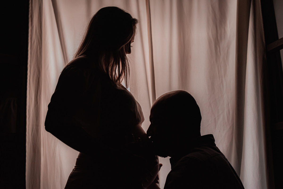 Foto do papai beijando a barriga da mamãe gestante.