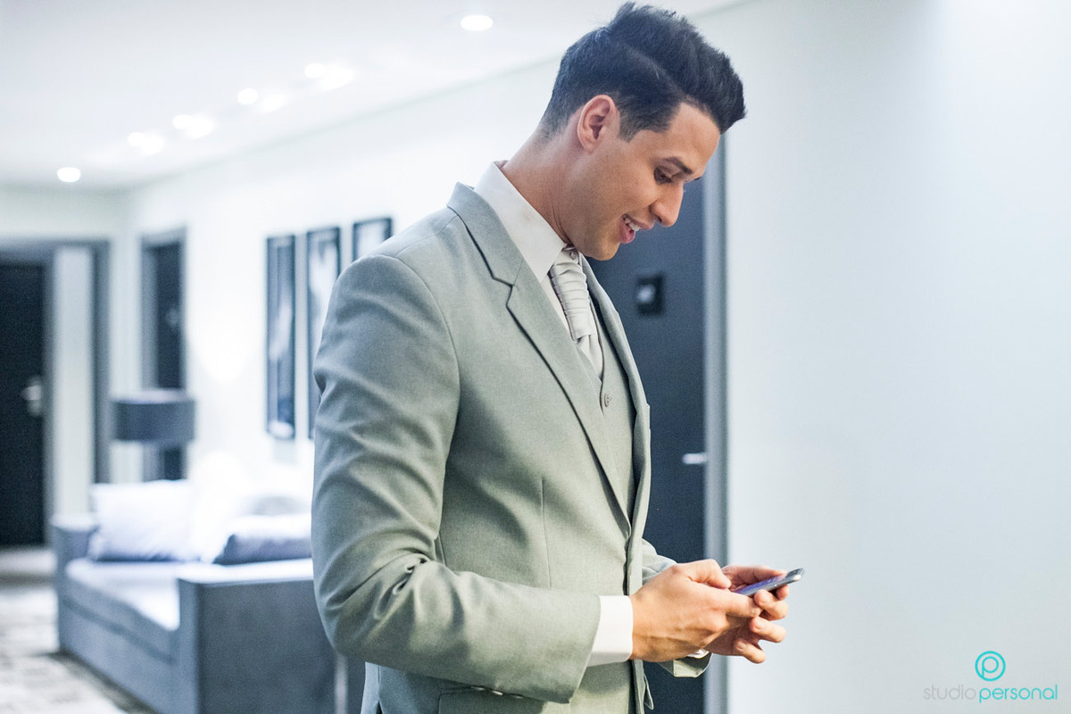 Casamento no buffet ilha do mehl em curitiba com decoracao da videira e fotos studio personal fotografias noivo vendo celularGiovanna e Vinicius | Curitiba – PR