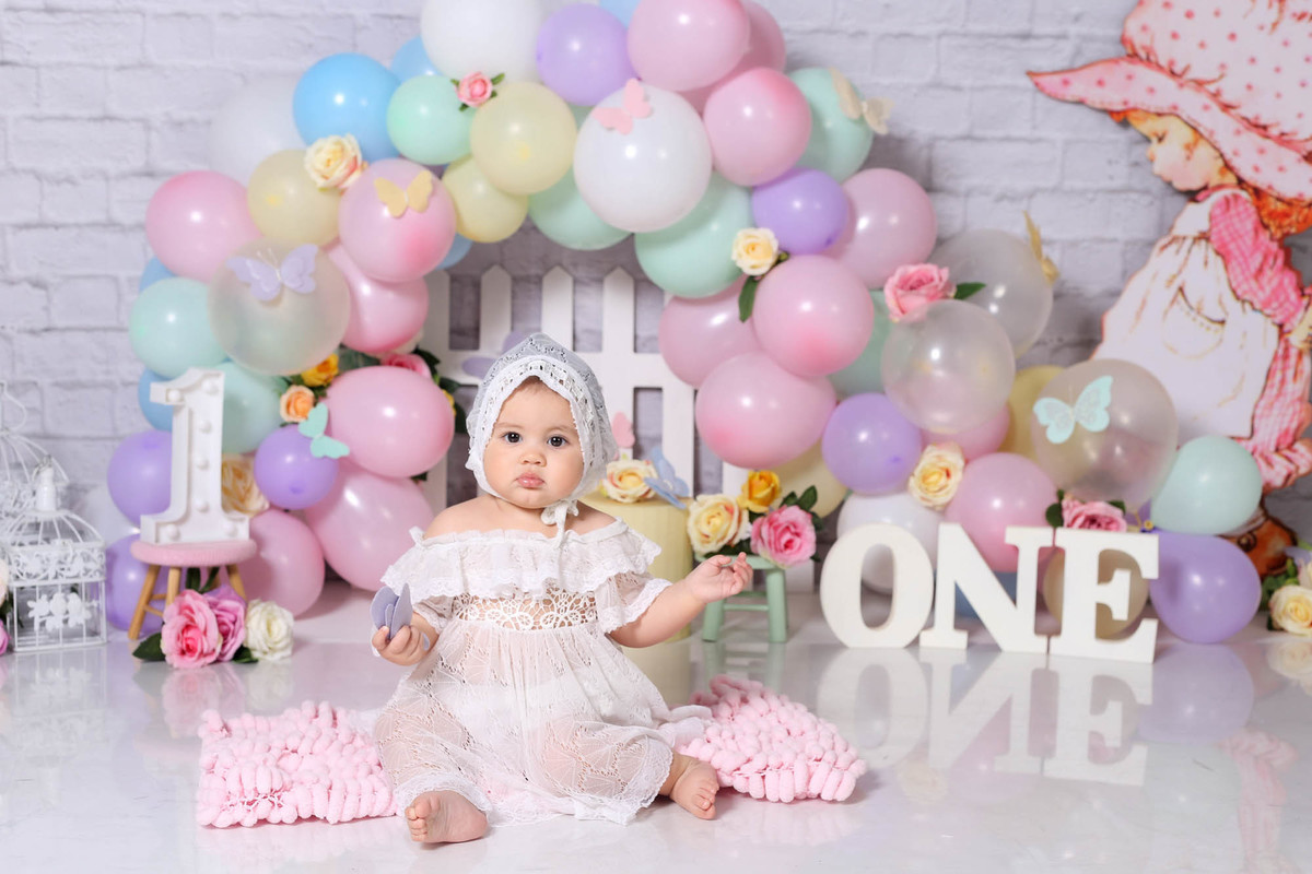 Foto cenário smash the cake de jardim com balões e flores
