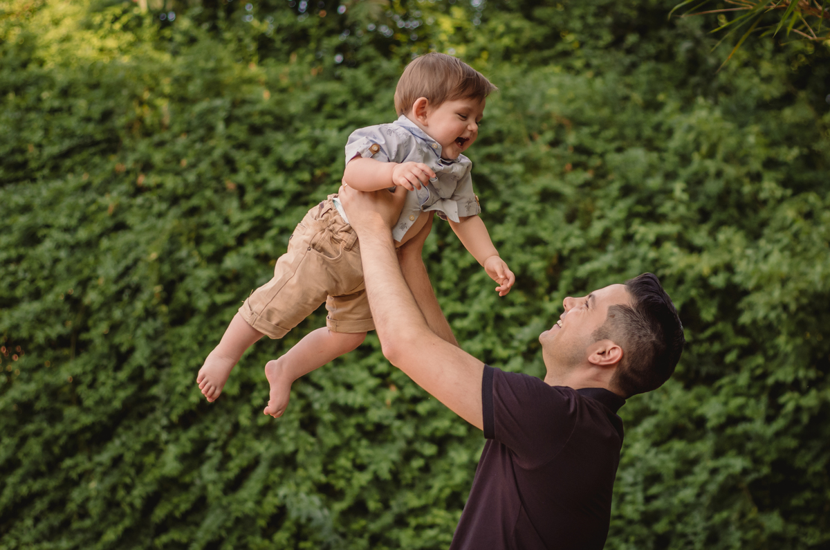 Pé na Terra | Lomba Grande | Novo Hamburgo - RS | Fundo Verde | Pai brincando com Bebê | Pai jogando bebê no ar | Bebê sorrindo