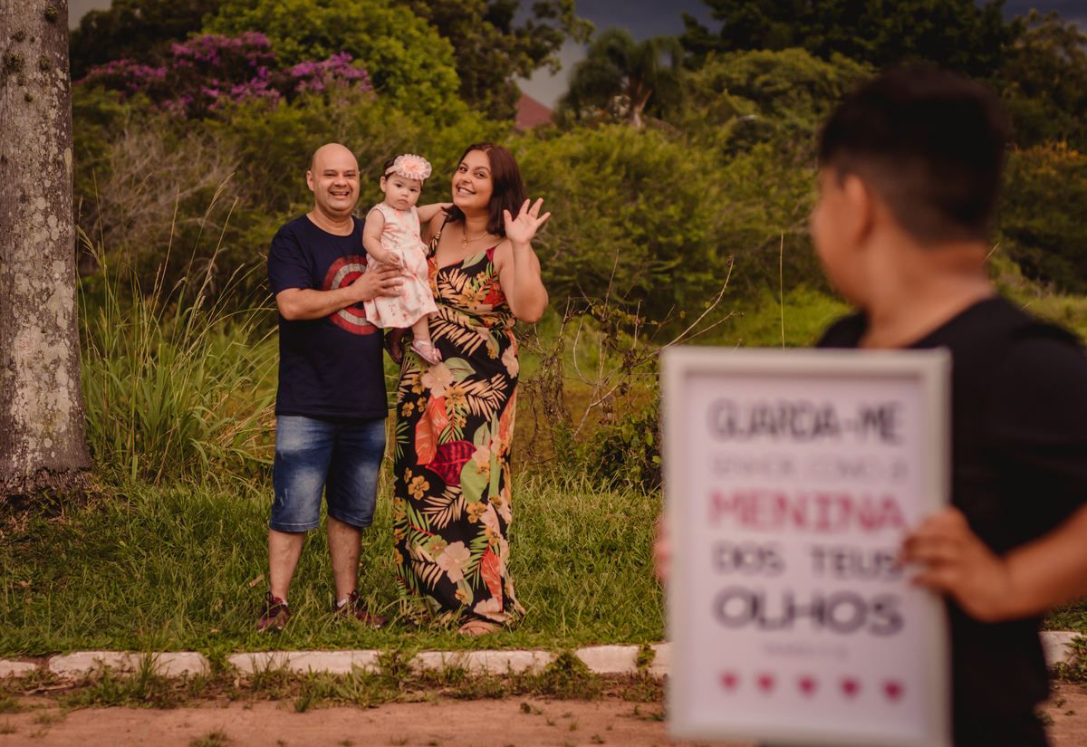 Book de Família em Canoas RS Fotógrafo de Família em São Leopoldo Fotos em família externo dia ensolarado dia nublado dia chuvoso capão do corvo parque getúlio vargas irmão segurando quadro e pais acenando
