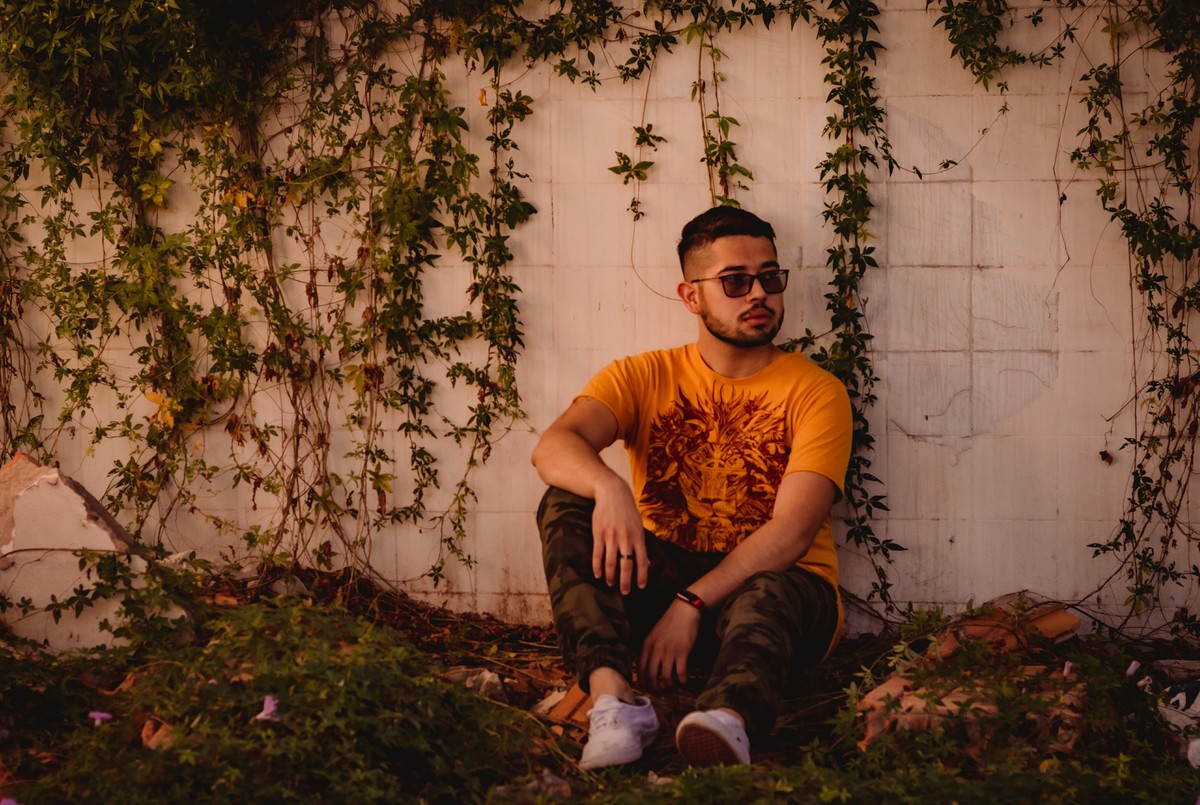 fotógrafo profissional em são leopoldo ensaio individual book pessoal camisa emaus emaús local abandonado fábrica abandonada book masculino estilo homem masculino ideias de ensaio fotografia autoral óculos escuro sentado sobre uma parede com raízes