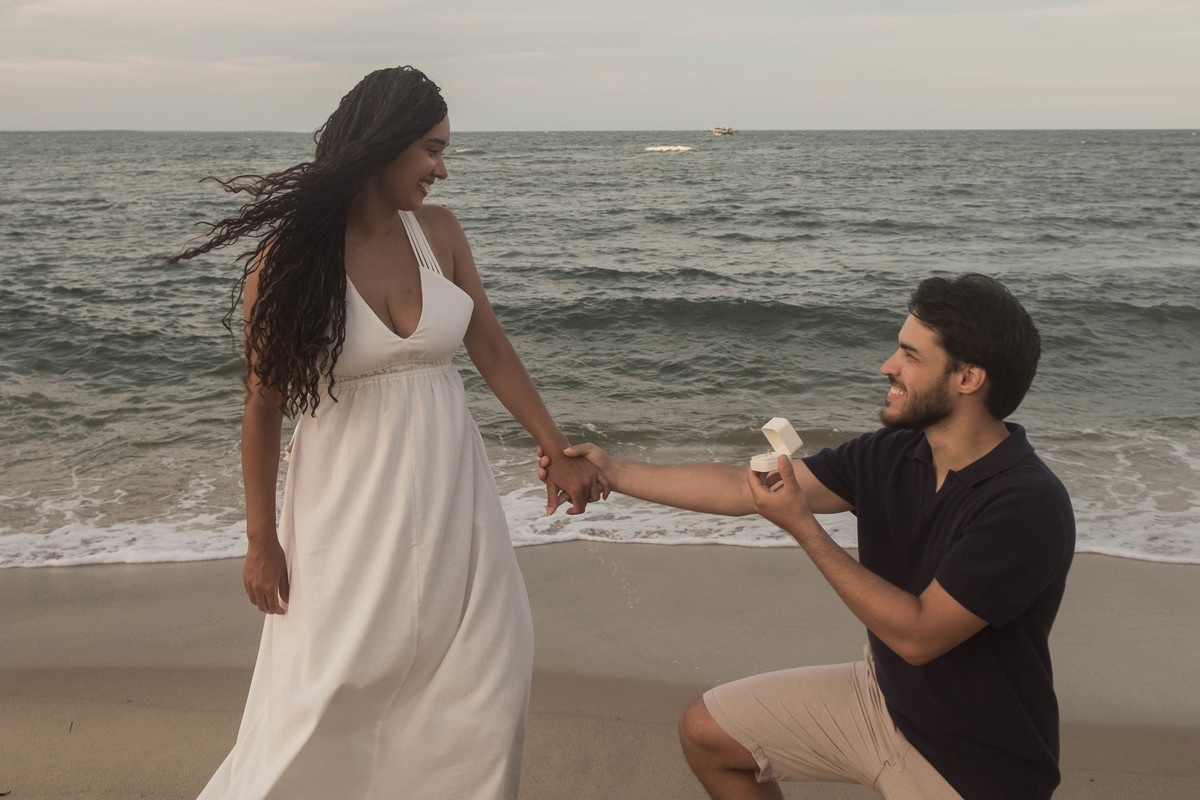 Pedido de casamento surpresa na praia em Boipeba, Bahia, registrado ao pôr do sol com emoção, espontaneidade e o mar ao fundo.