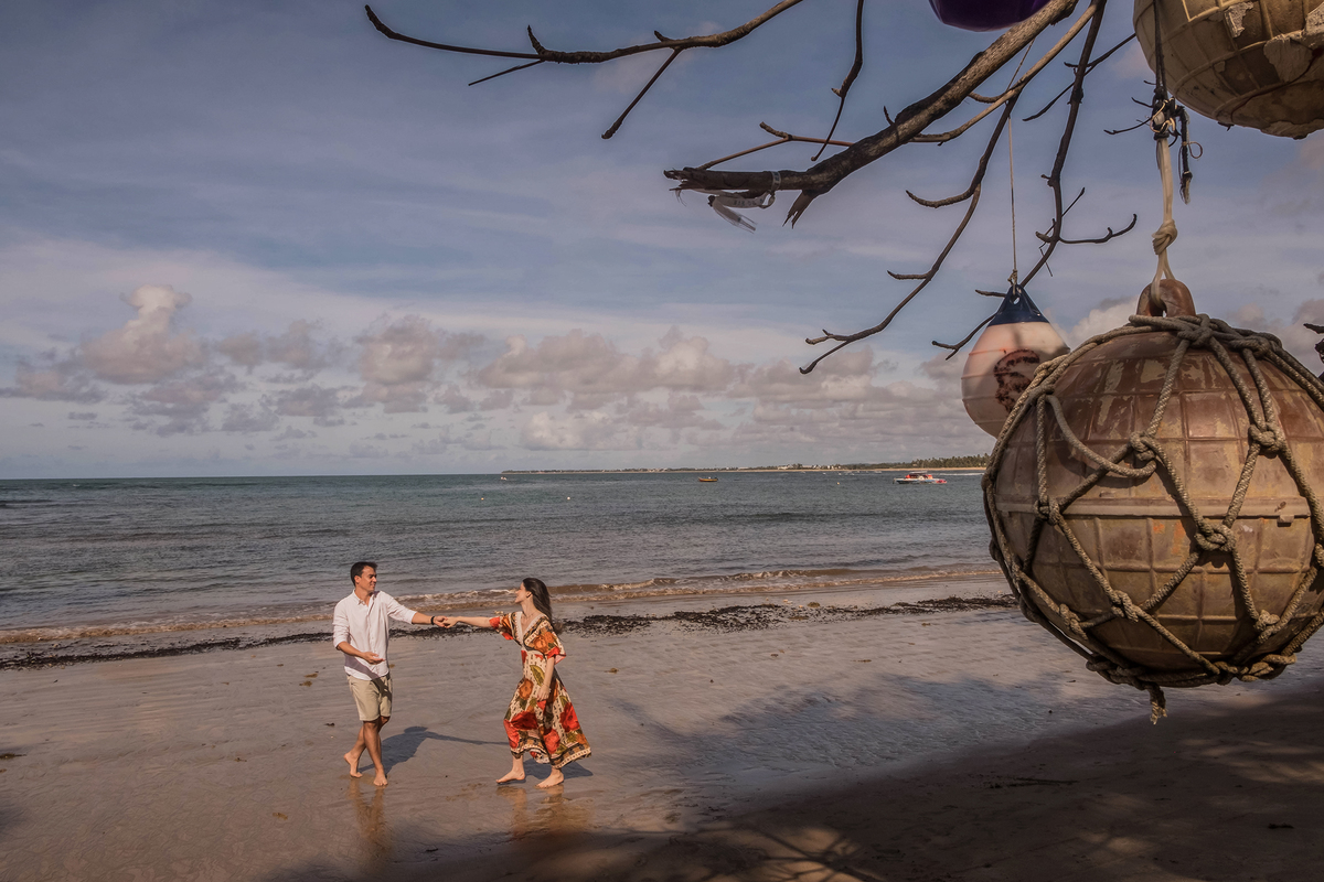 Saulo e Maene durante ensaio de casal em Praia do Forte, Bahia, em um dia de céu azul e maré baixa.