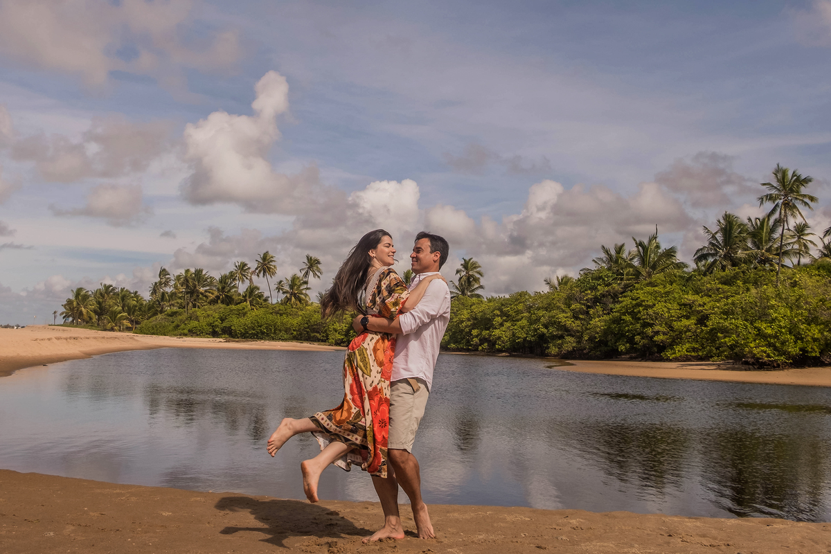 Saulo carregando Maene e girando com ela na praia durante ensaio fotográfico do casal.