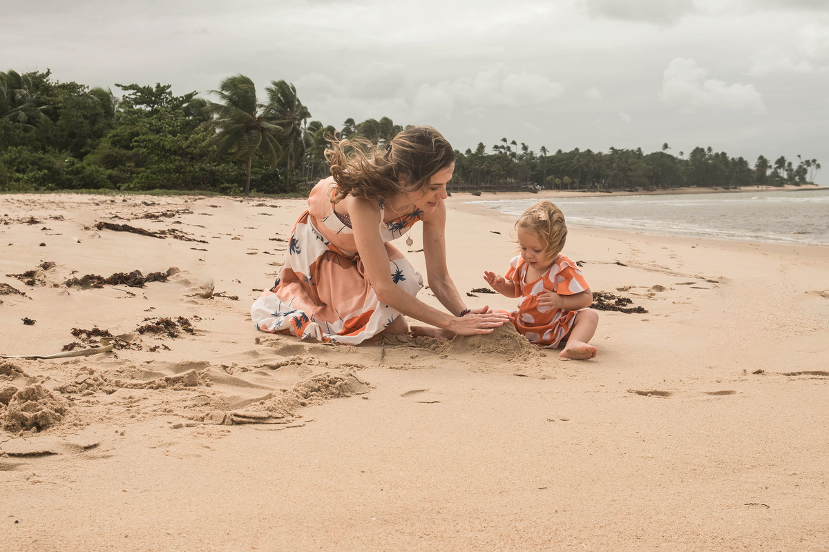 Mayara brincando com a filha na areia durante o ensaio de família  em Praia do Forte.