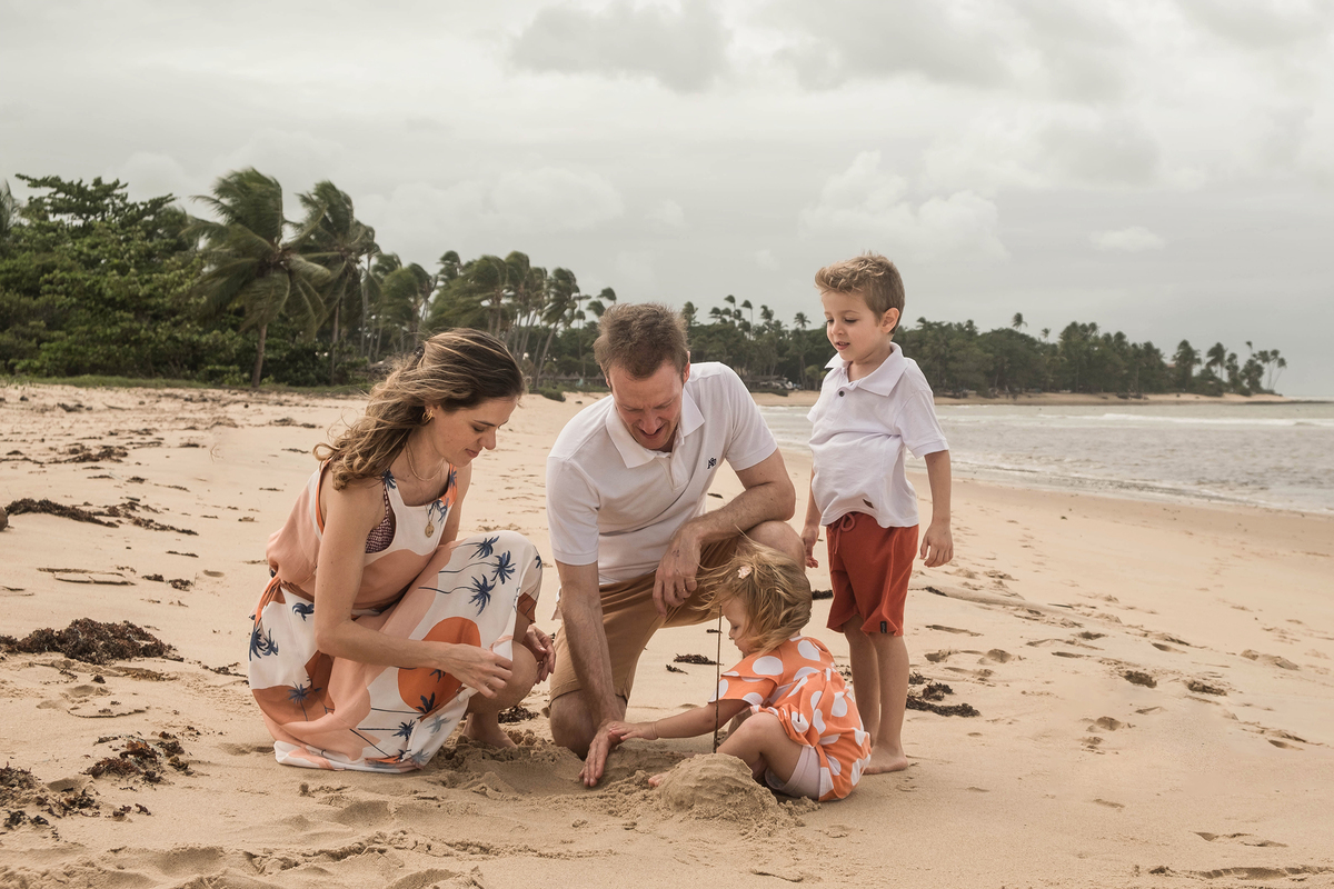 Mayara, Denis e os dois filhos durante ensaio de família na praia em Praia do Forte, Bahia.