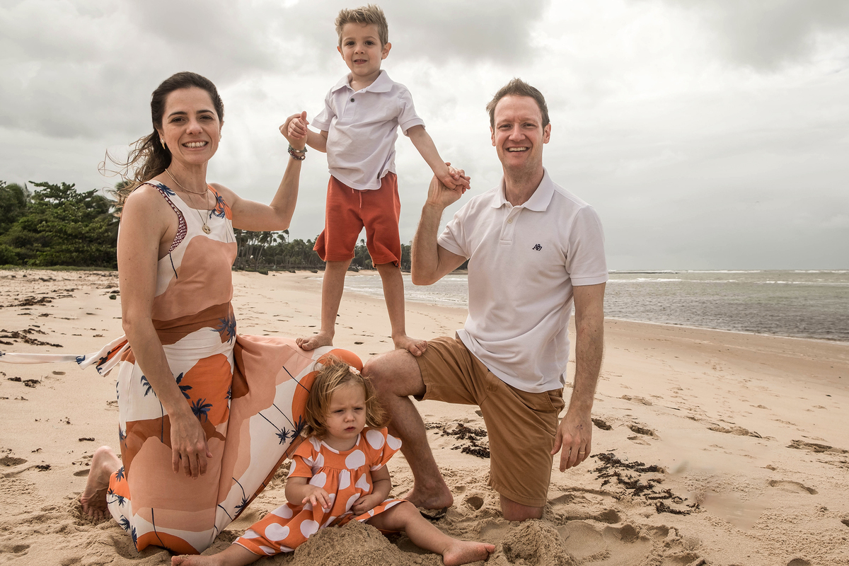 Mayara, Denis e os dois filhos durante ensaio de família na praia em Praia do Forte, Bahia.