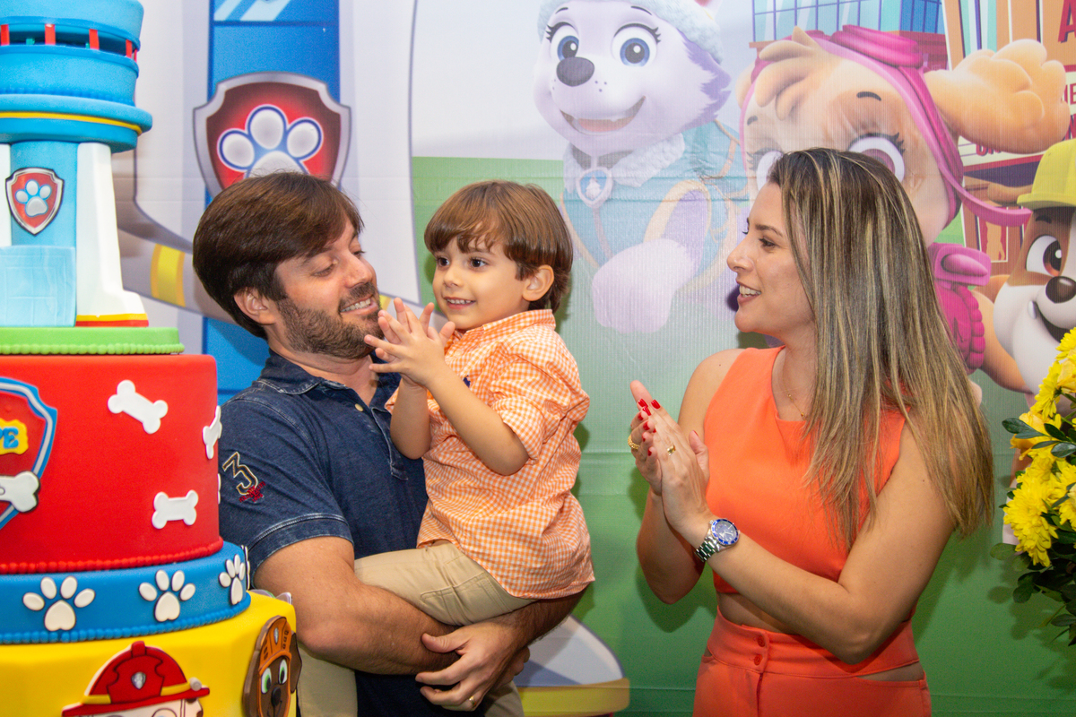 Pai e mãe batendo parabéns para o filho 
