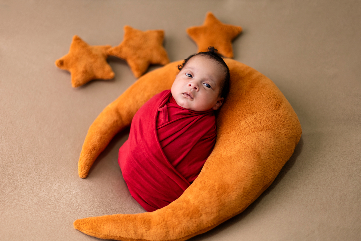 newborn enroladinho com Lua posing e estrelas marrom