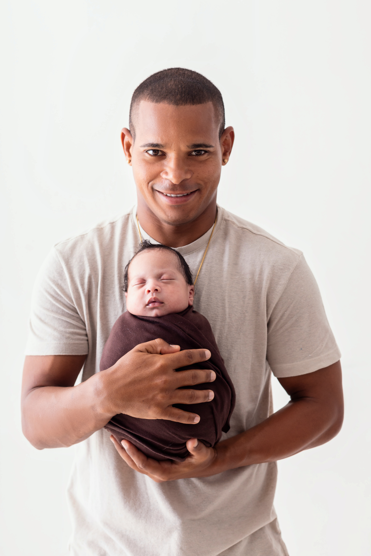 papai segurando bebê enroladinho