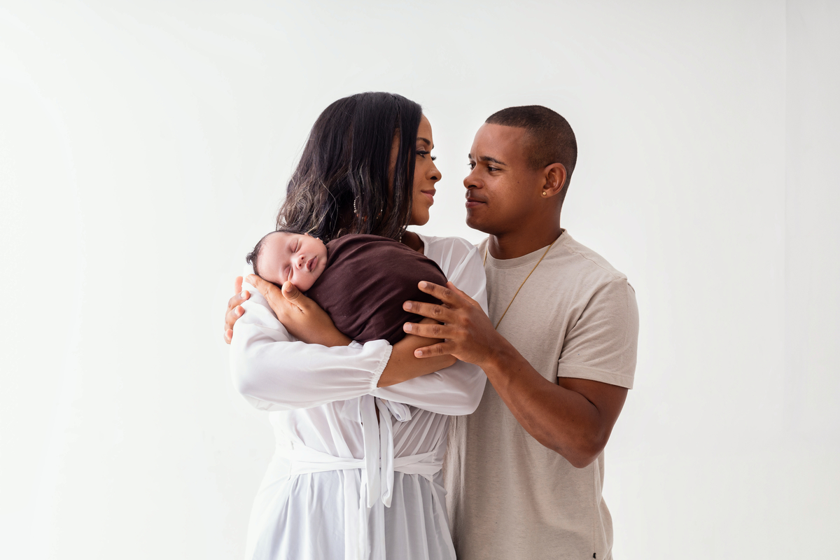 mamãe e papai abraçando seu bebê enroladinho