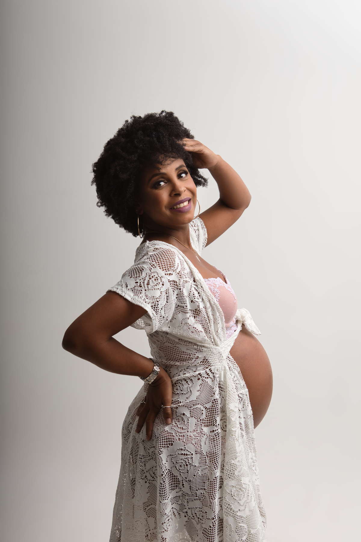 gestante boudoir com mão na cintura e outra no cabelo