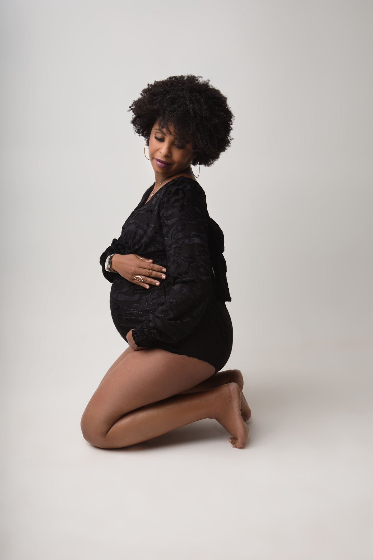 gestante boudoir ajoelhada abraçando a barriga