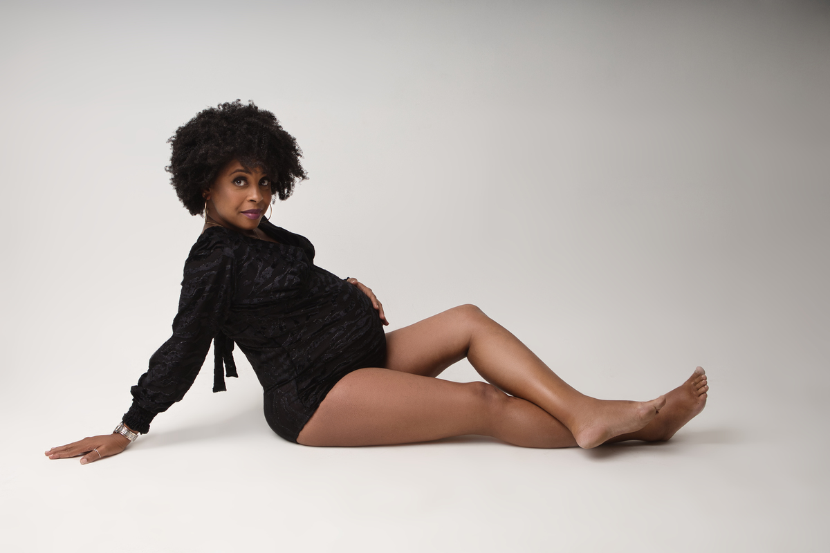 gestante boudoir sentada inclinada e tocando na barriga