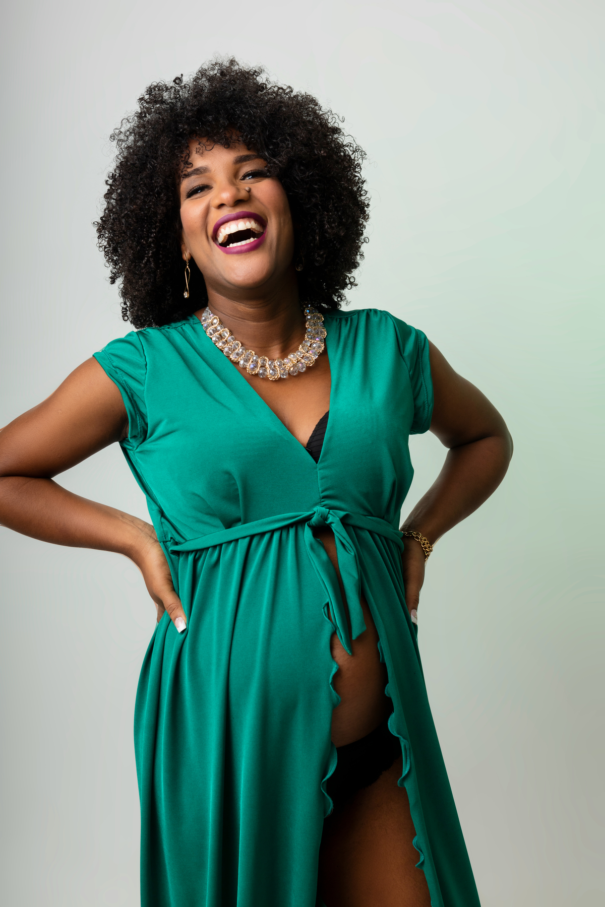 gestante de vestido com as mãos na cintura