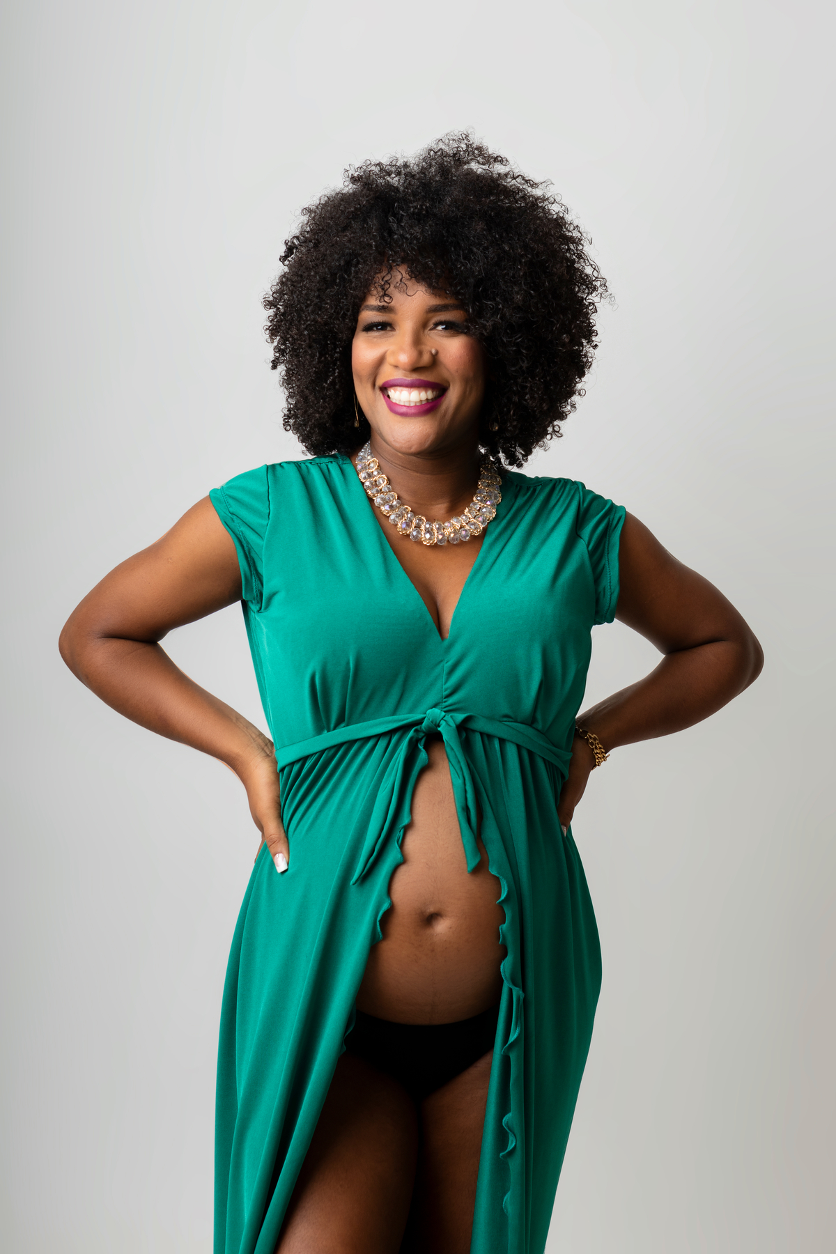 gestante de vestido com as mãos na cintura