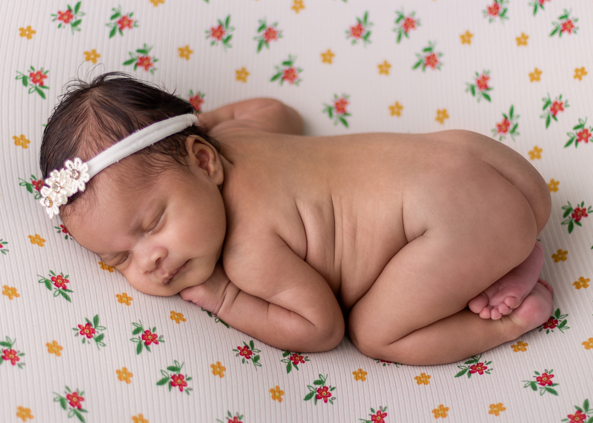 newborn de bruços com tiara