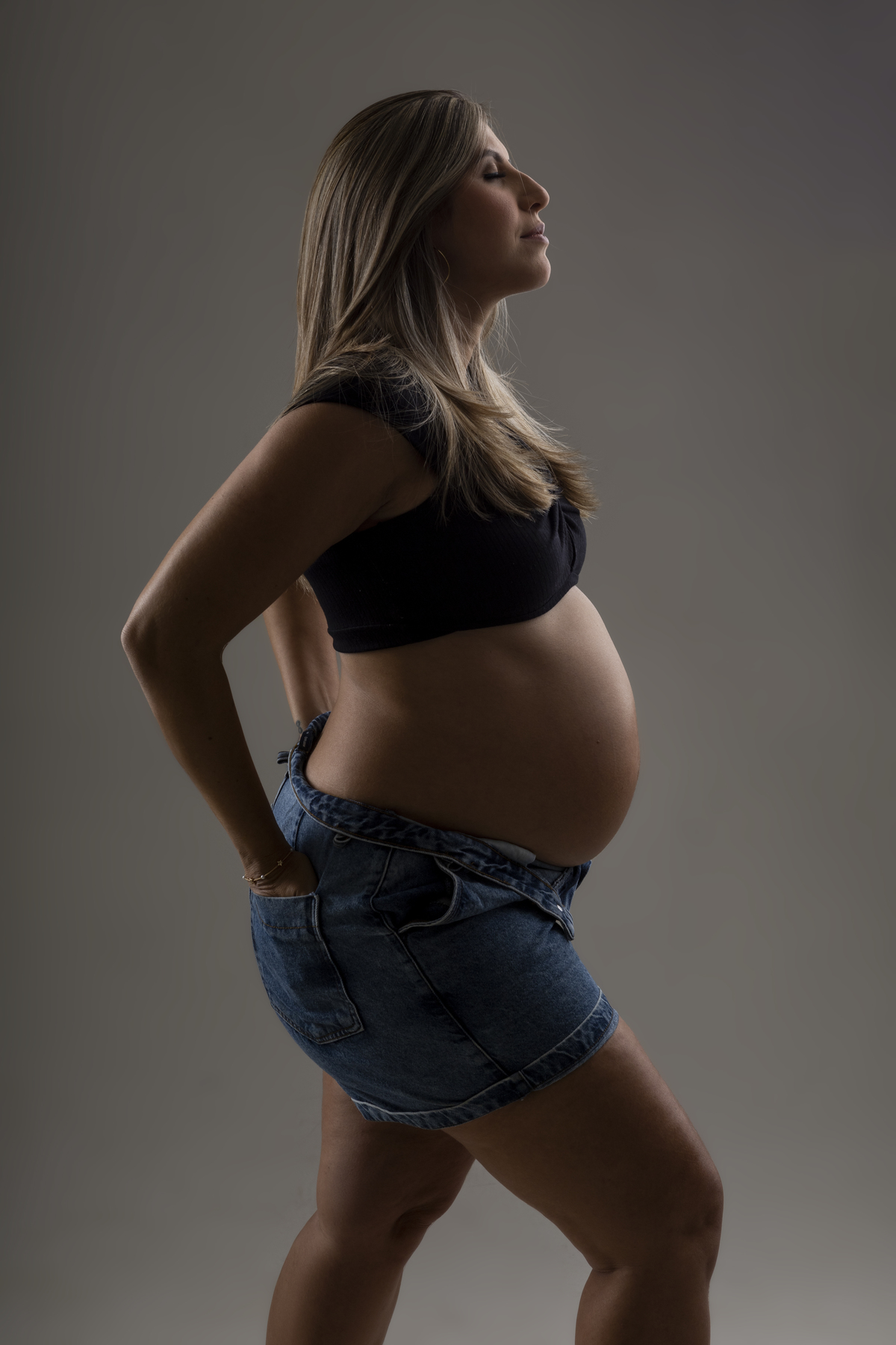 gestante com short jeans com as mãos no bolso