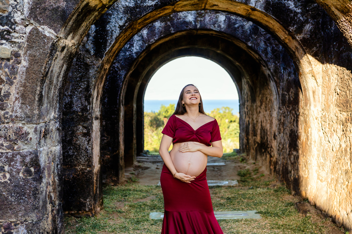 gestante abraçando a barriga com conjunto vermelho 
