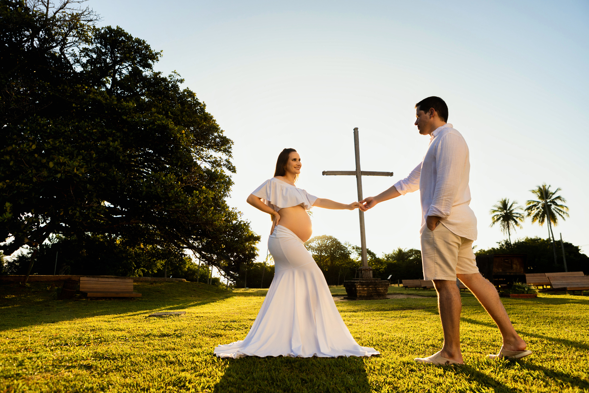 mamãe com mão na cintura e puxando papai com conjunto branco