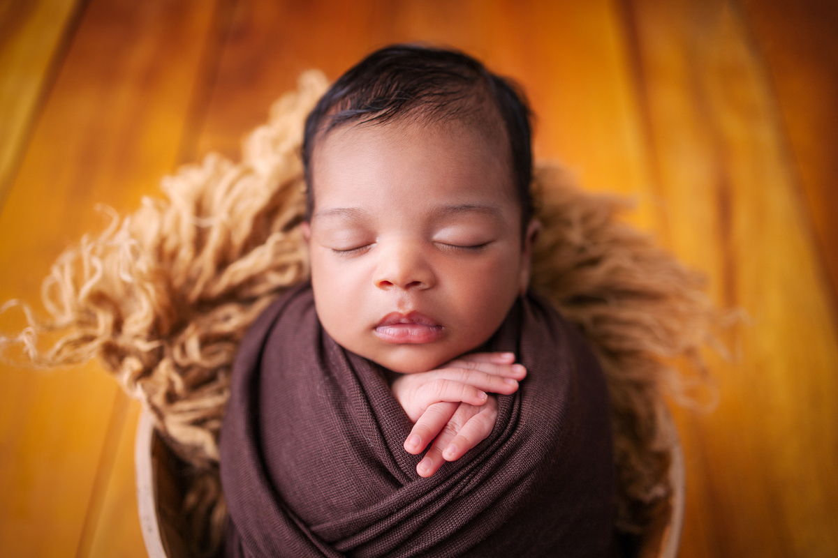 wrap newborn marrom e props balde apoiando as mãos