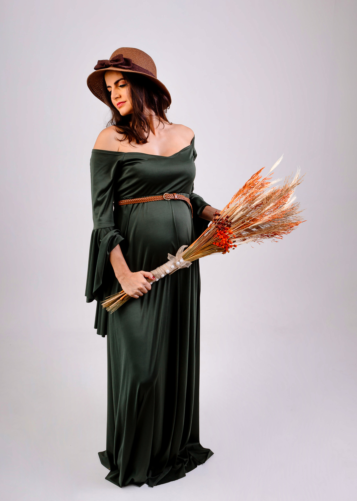 gestante com chapéu segurando buquê de trigo