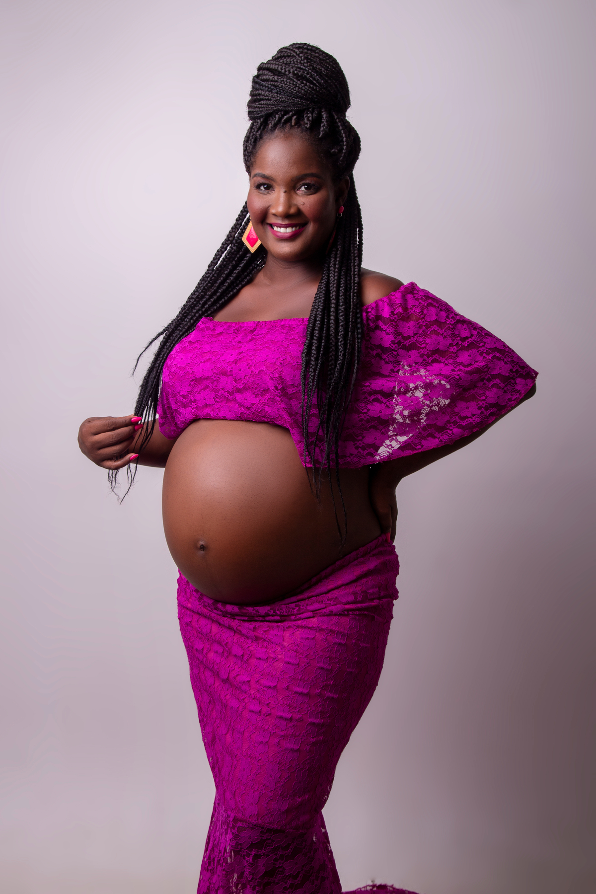 gestante com conjunto roxo com mão na cintura e outra segurando o cabelo