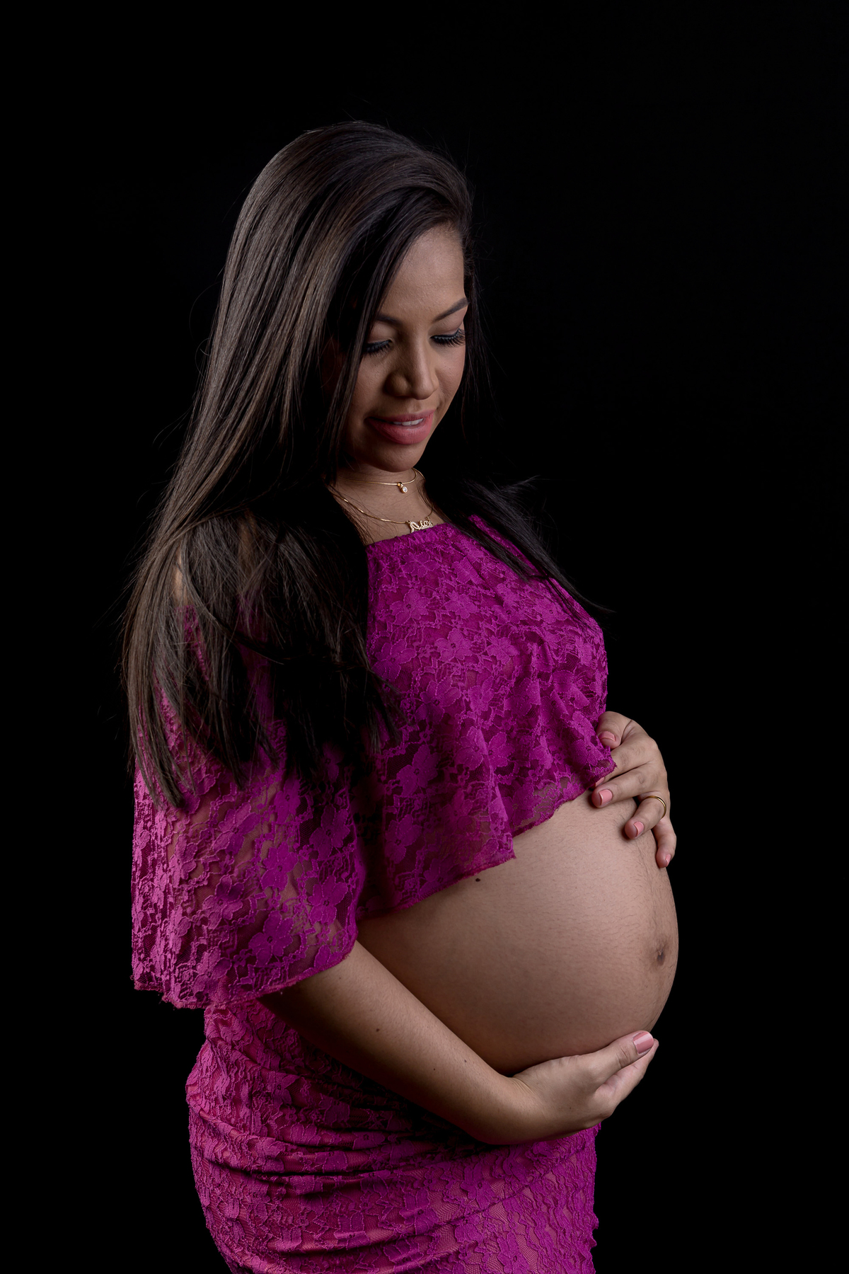 gestante com conjunto roxo abraçando a barriga