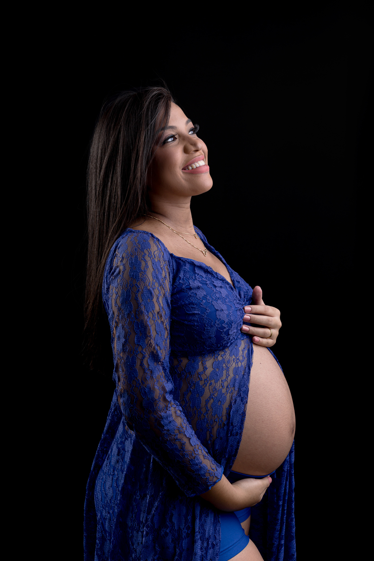 gestante com vestido azul abraçando a barriga