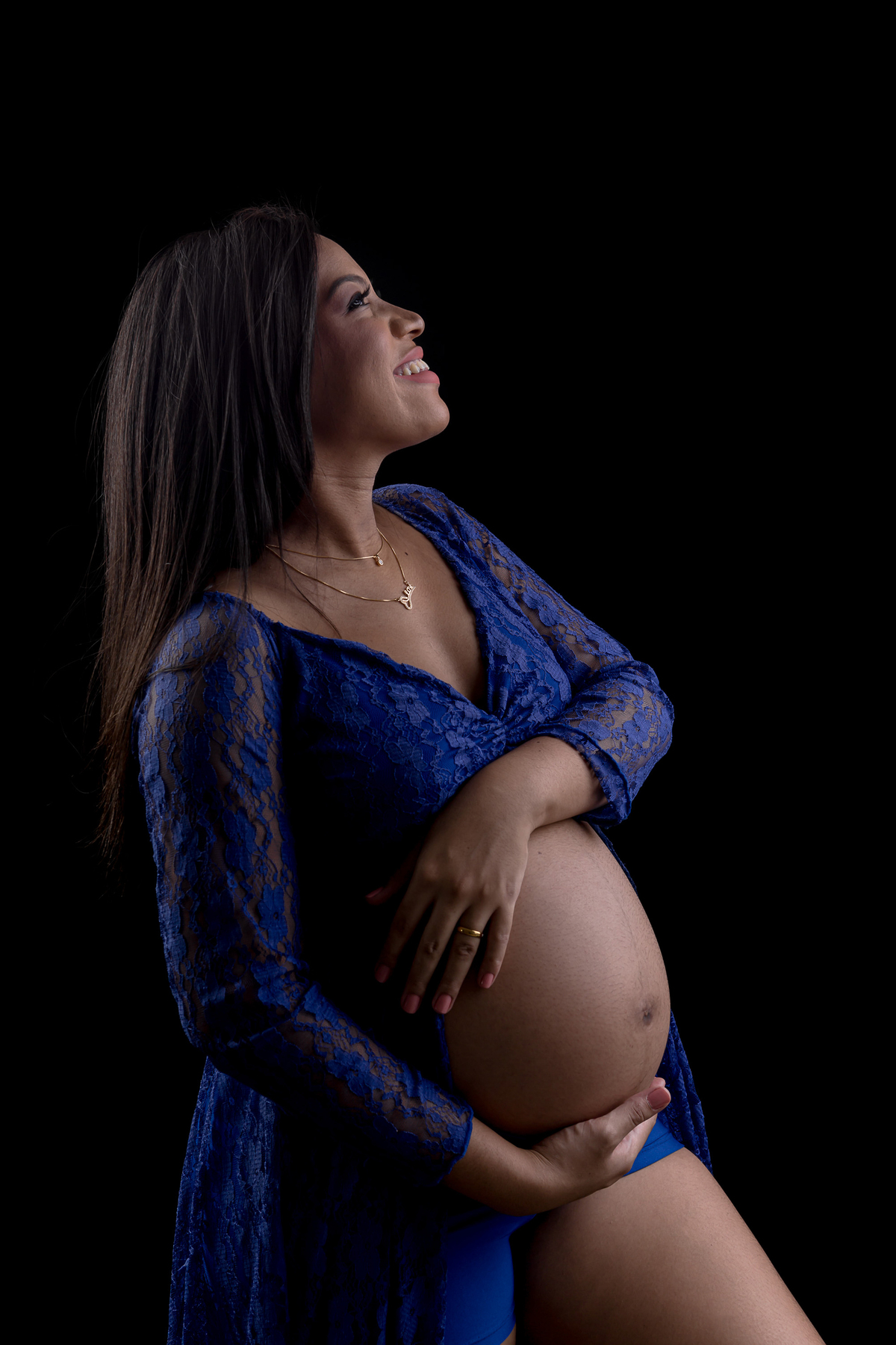 gestante com vestido azul abraçando a barriga