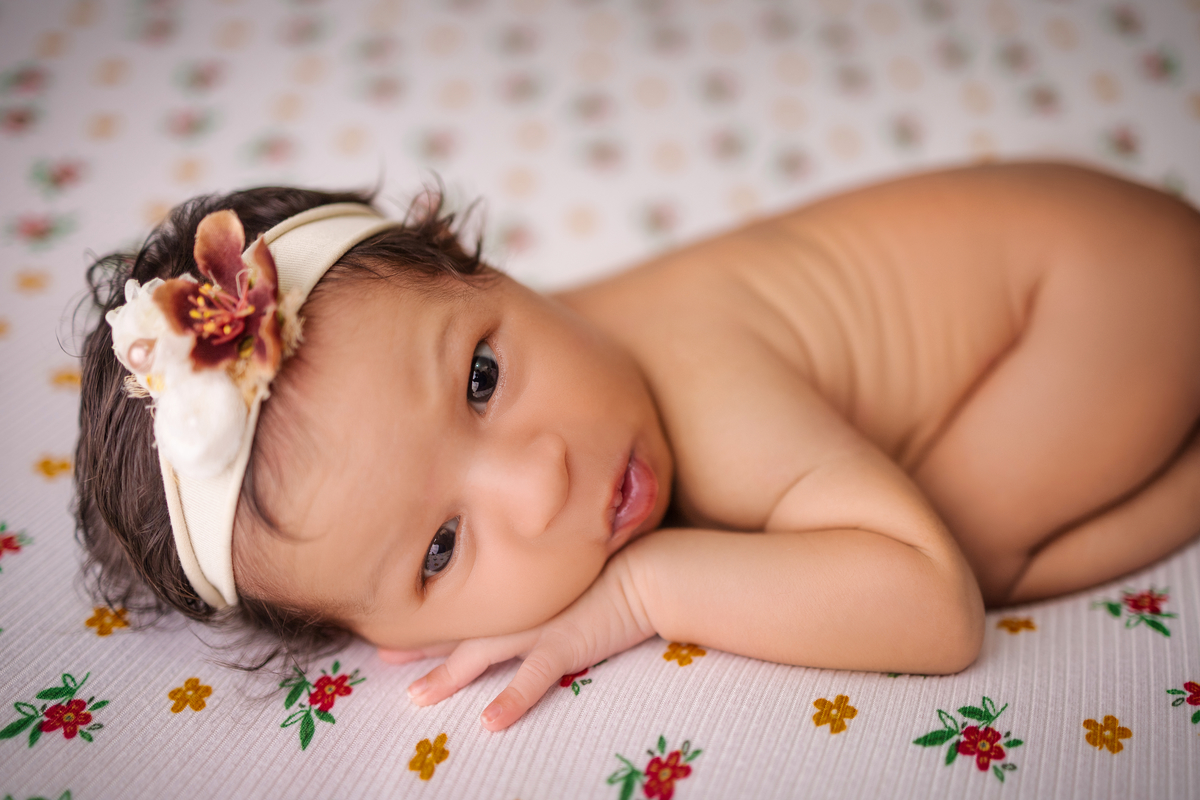 newborn de bruços com tiara