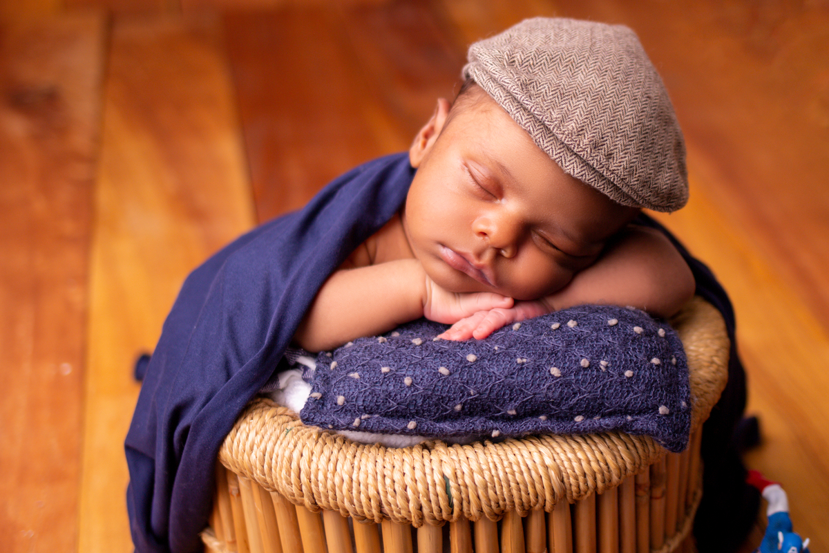 newborn coberto no balde com boina