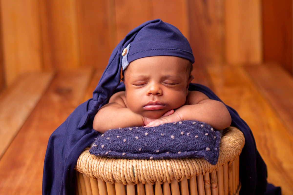 newborn coberto no balde com gorro
