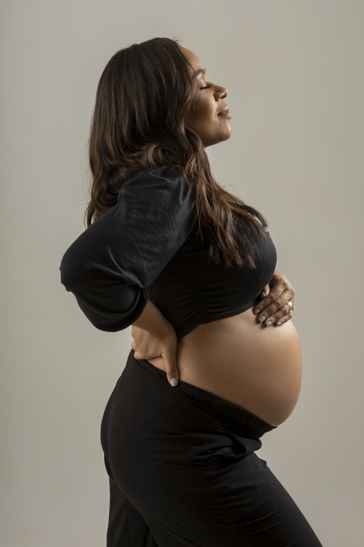 gestante com a mão na cintura e outra na barriga