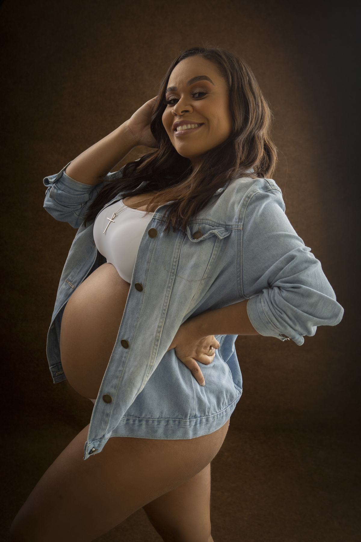 gestante com a mão no cabelo e outra na cintura