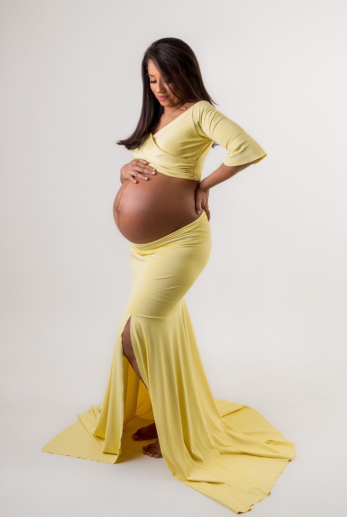 gestante com a mão da barriga e outra na cintura