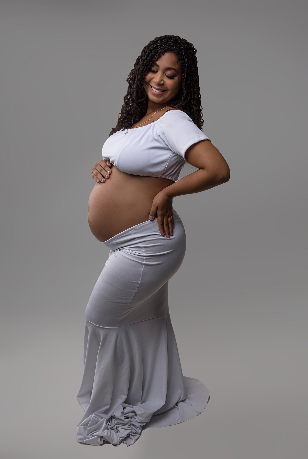 gestante com mão na barriga e outra na cintura