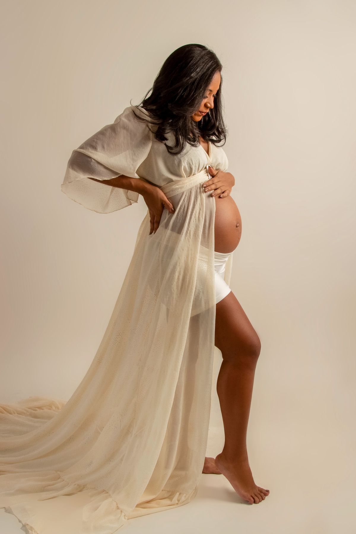 gestante com a mão da barriga e outra na cintura