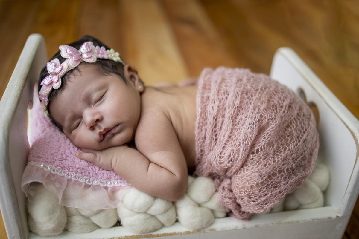 newborn de bruços na props cama 