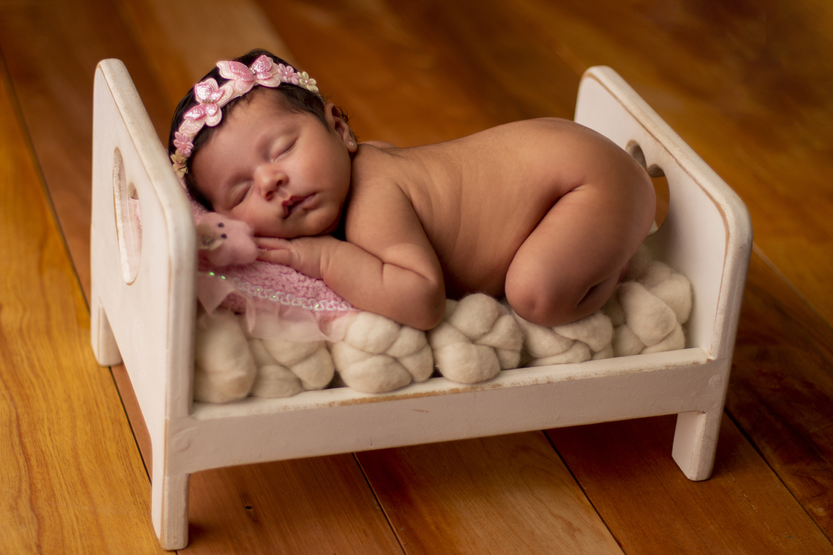 newborn de bruços na props cama 