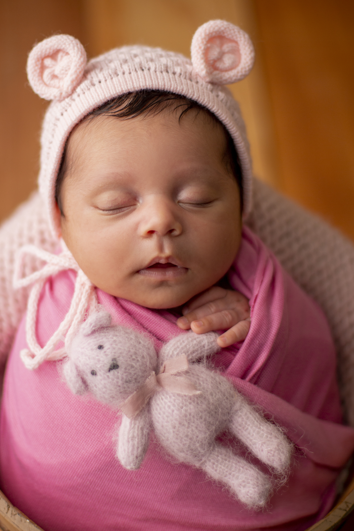 wrap newborn rosa e props balde segurando ursinho