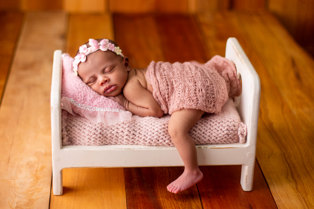 newborn de bruços na props cama 